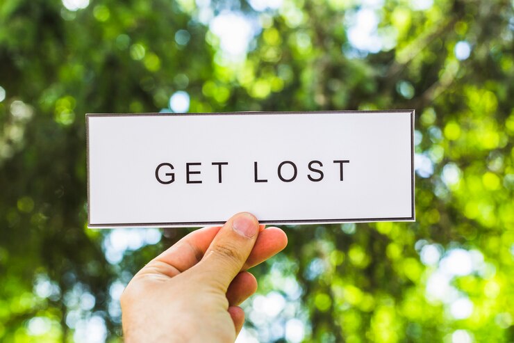 मुफ़्त फोटो hand holding placard with get lost text