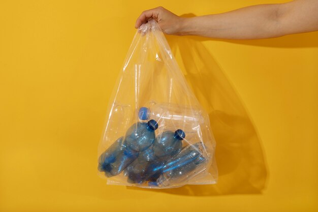 Hand holding plastic bag with bottles