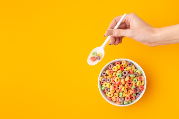Hand holding plastic spoon with cereal
