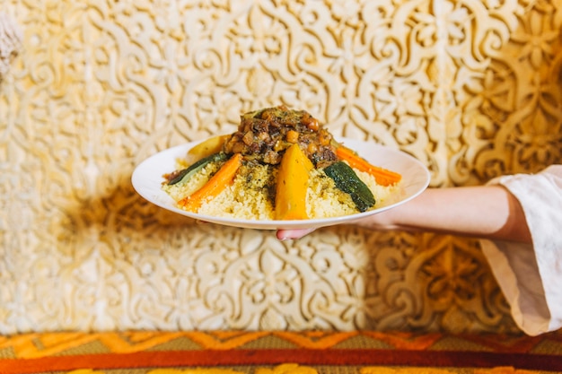 Hand holding plate of arab food