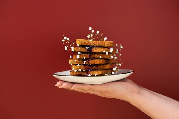 Hand holding plate with toast and flowers