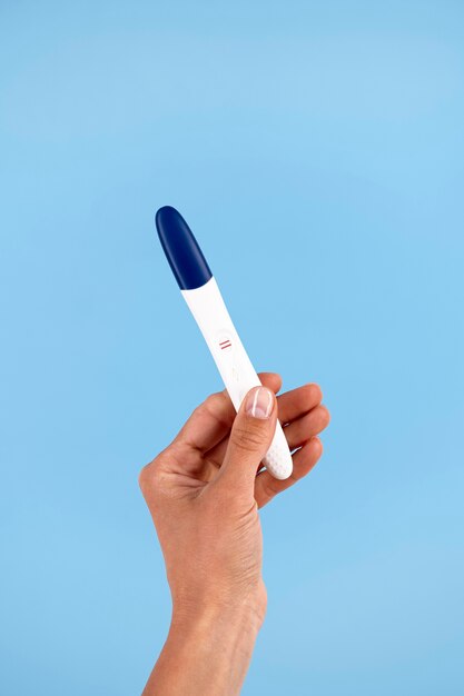 Hand holding positive pregnancy test