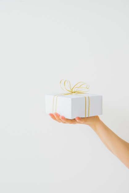 Hand holding present wrapped with ribbon