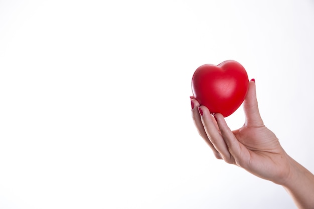 Free photo hand holding red plastic heart