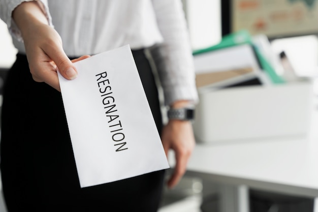 Hand holding resignation note high angle