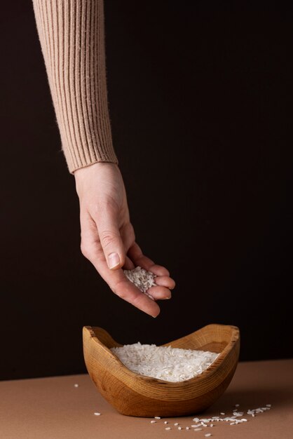 Hand holding rice from bowl zakat concept