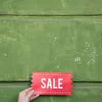 Free photo hand holding sale sign