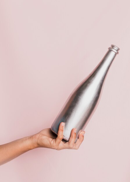 Hand holding silver champagne bottle