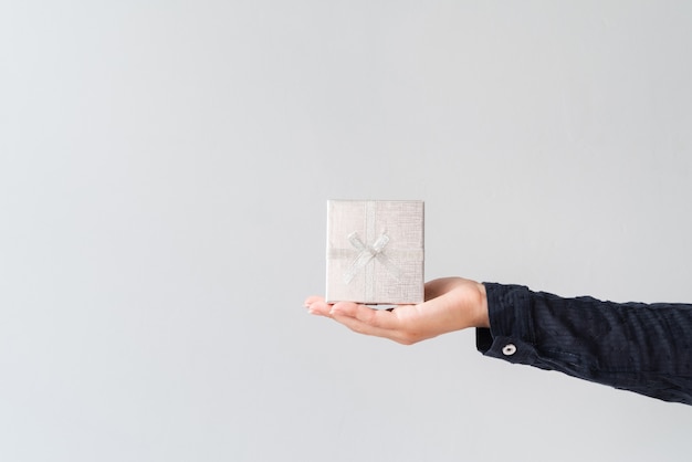 Hand holding silver wrapped gift