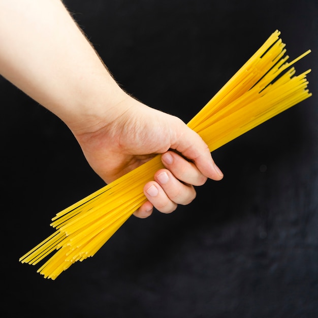 Hand holding spaghetti