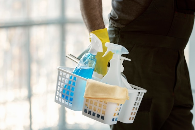 Free photo hand holding stand with cleaning products