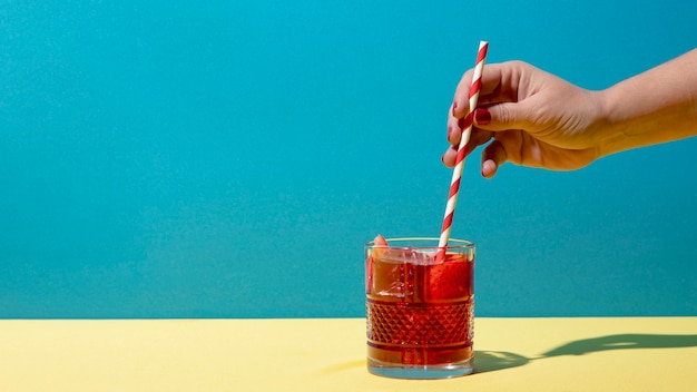 Hand holding straw with sangria drink