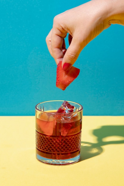 Free photo hand holding strawberry for sangria