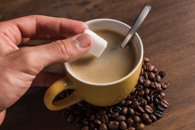 커피 컵 근처 설탕을 들고 손