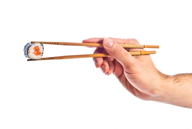 hand holding sushi with chopsticks