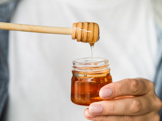 Free photo hand holding sweet honey jar