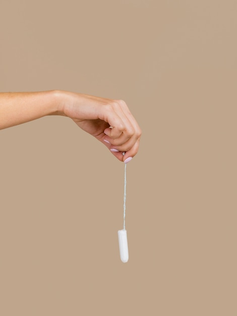 Free photo hand holding a tampon front view