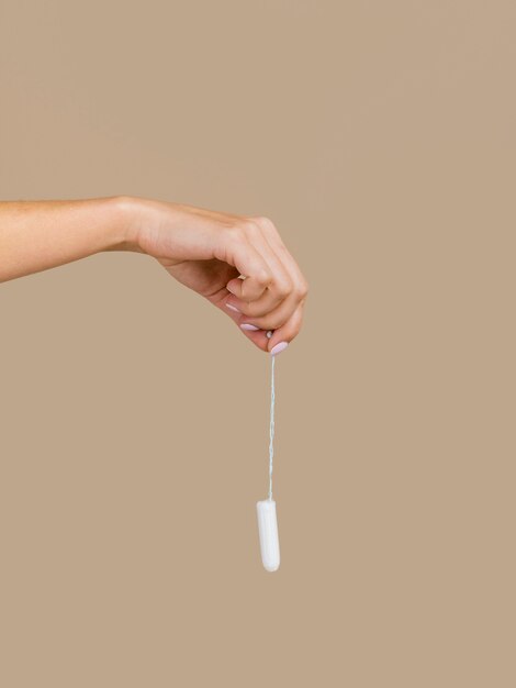 Hand holding a tampon front view