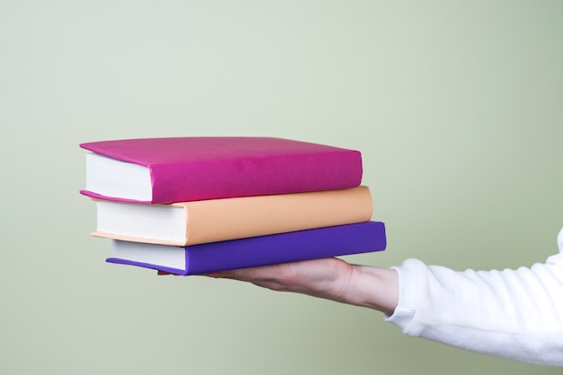 Hand holding three books