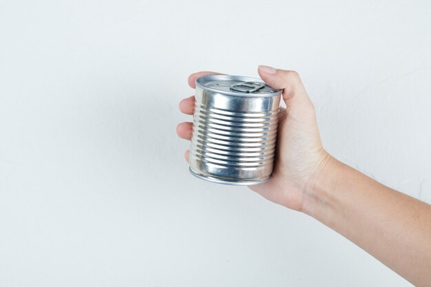 Hand holding a tin can of boiled sweet corn.