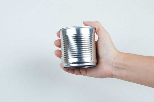 Hand holding a tin can of boiled sweet corn.