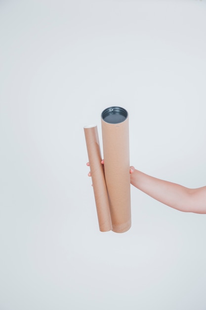 Hand holding two cardboard tubes
