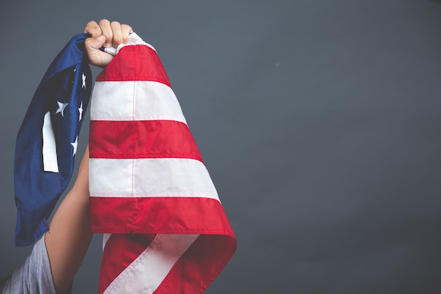 Hand holding USA flag on dark background