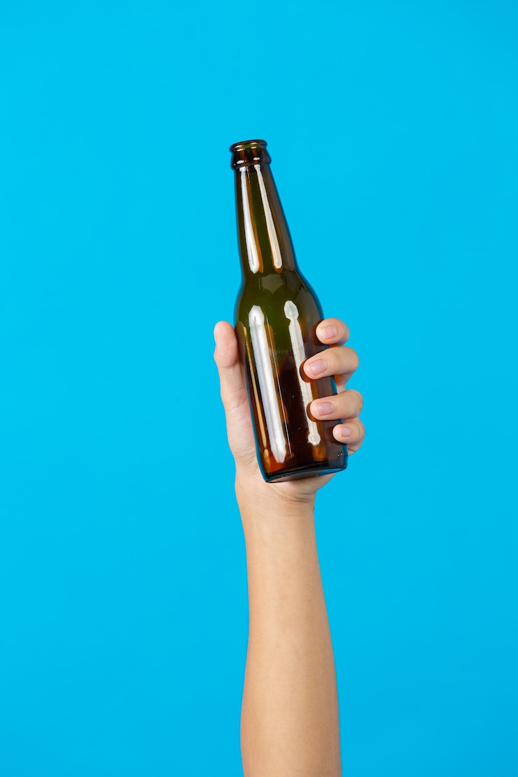 Free Photo hand holding used bottle on blue background