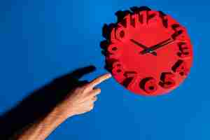 Free photo hand holding wall clock still life