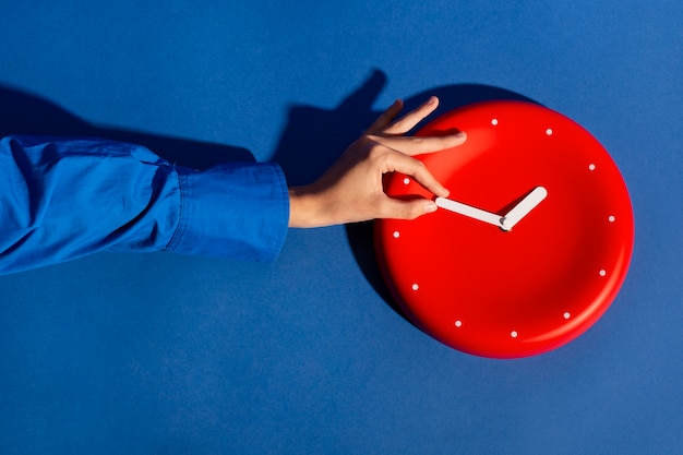 Free photo hand holding wall clock still life