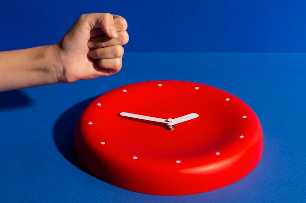 Free photo hand holding wall clock still life