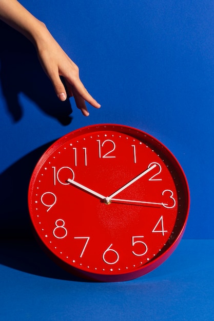 Free photo hand holding wall clock still life