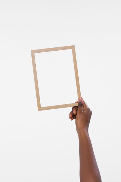 Hand holding wooden frame with white background