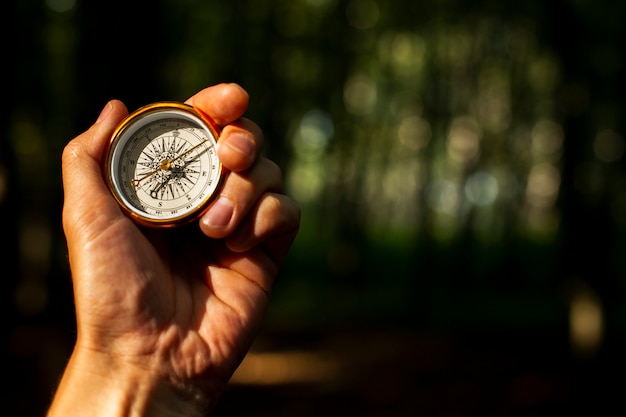 Hand holds a compass with blurred background