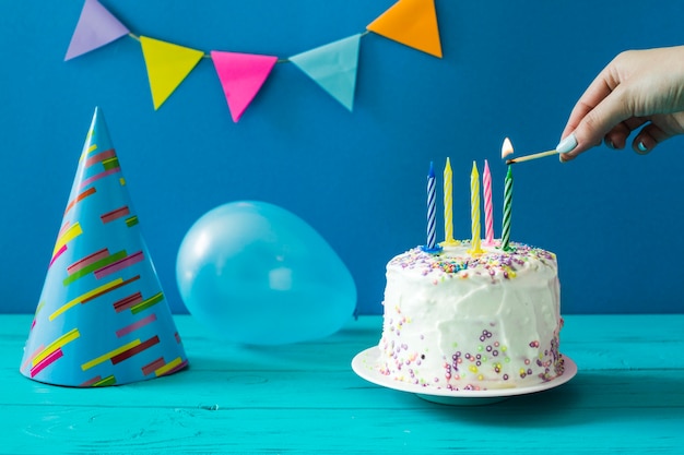 Foto gratuita candele di illuminazione a mano sulla torta di compleanno