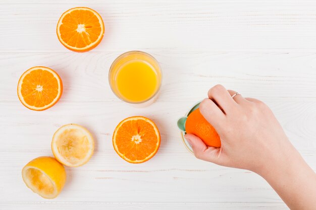Hand making orange juice
