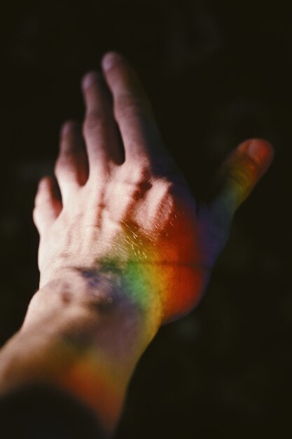 Hand of a male with a rainbow texture on the side