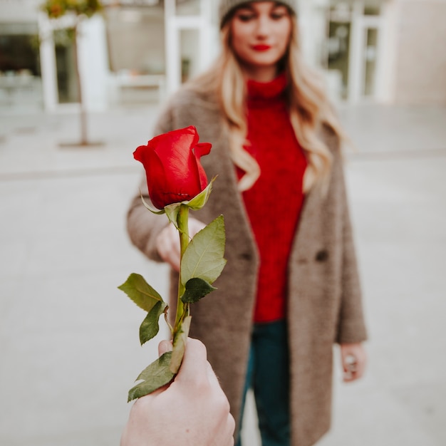 Hand of man giving rose to girlfriend