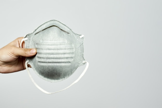 Hand of a person holding a personal protective face mask