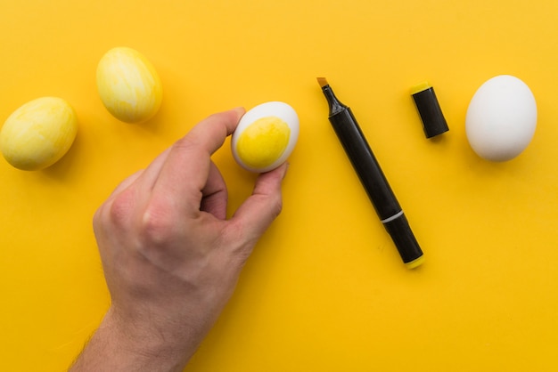 Рука человека возле маркера и яйца