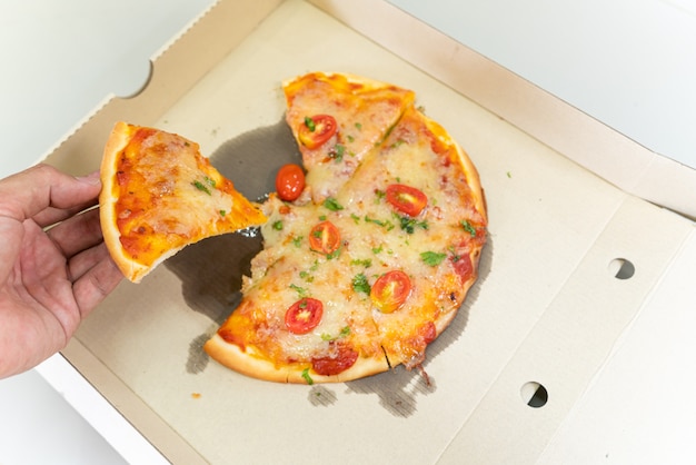 ピザ​の​昼食​または​夕食​の​皮​シラミ​の​トッピング​ソース​の​トウガラシ​-​ピーマンボードボックス​で​伝統的​な​ファースト​フード​を​拾って​手​。