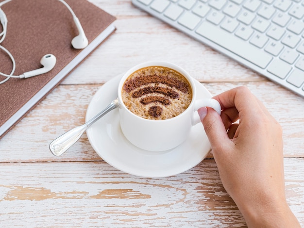 Foto gratuita mano raccogliendo la tazza con il simbolo wifi