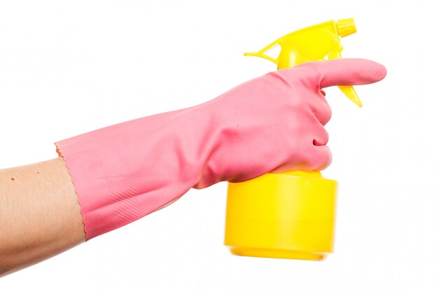 スプレーボトルを保持しているピンクの手袋で手します。