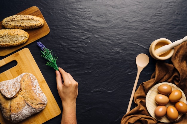 Free photo hand placing flower next to bread