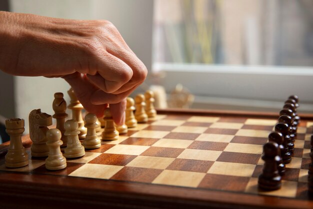 Hand playing chess on classic board