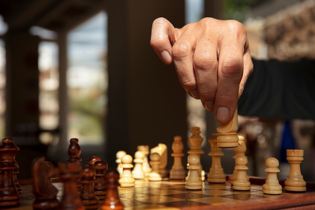 Hand playing chess on classic board