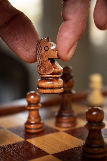 Hand playing chess on classic board