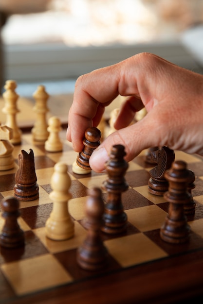hand playing chess on classic board