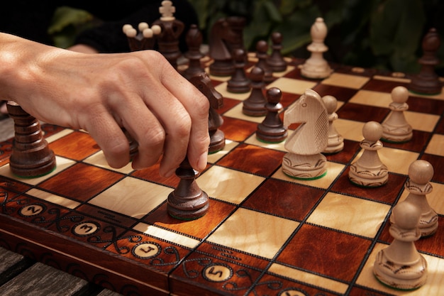 Foto gratuita mano che gioca a scacchi sulla tavola classica