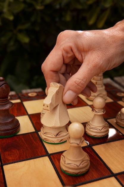 Hand playing chess on classic board